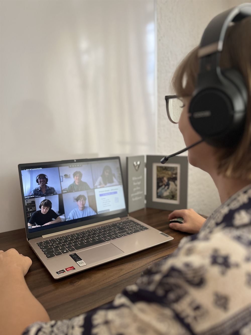 La maestra dando clase de inglés en línea frente a su computadora